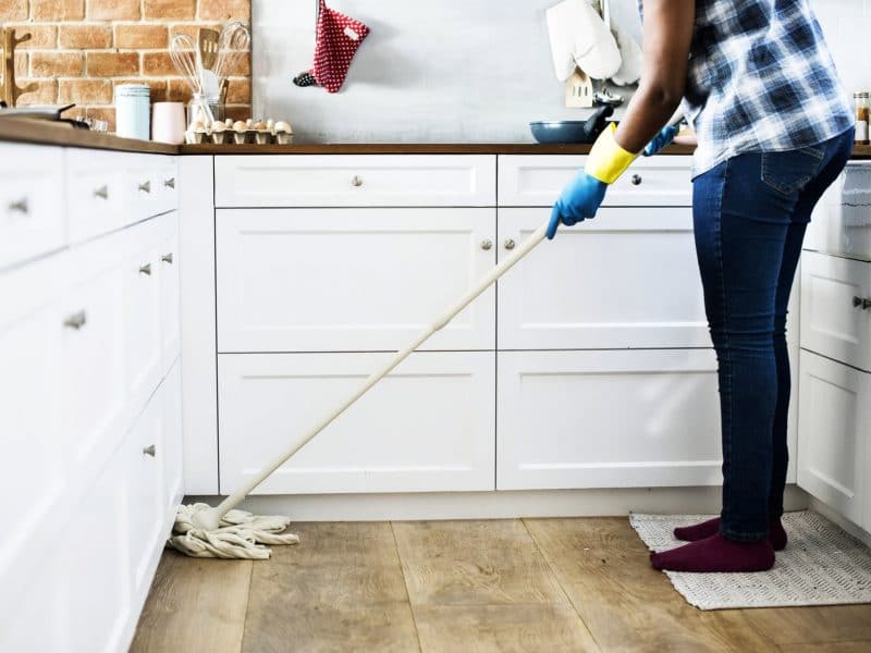 Lady Cleaning Kitchen Floor — Removalist in Brisbane, QLD